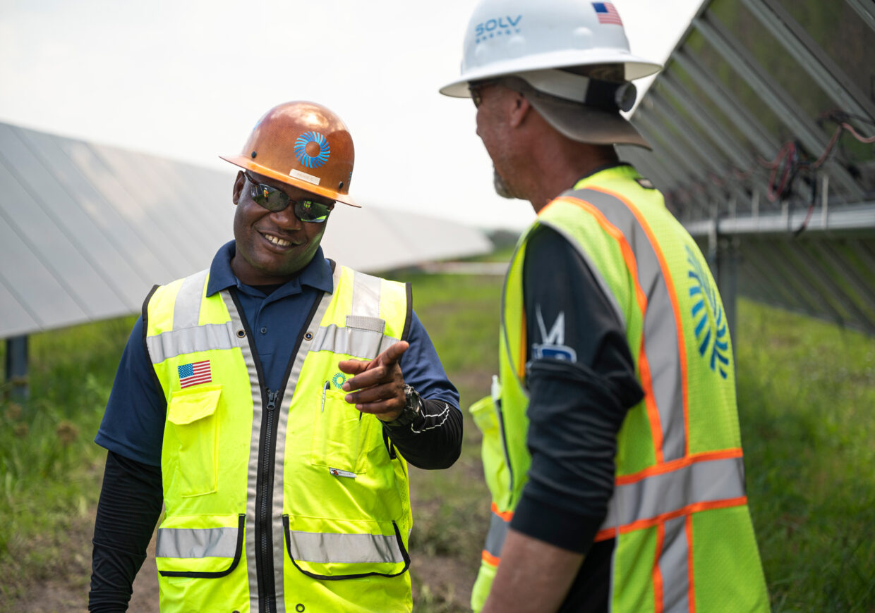 Two men chatting in the field at work